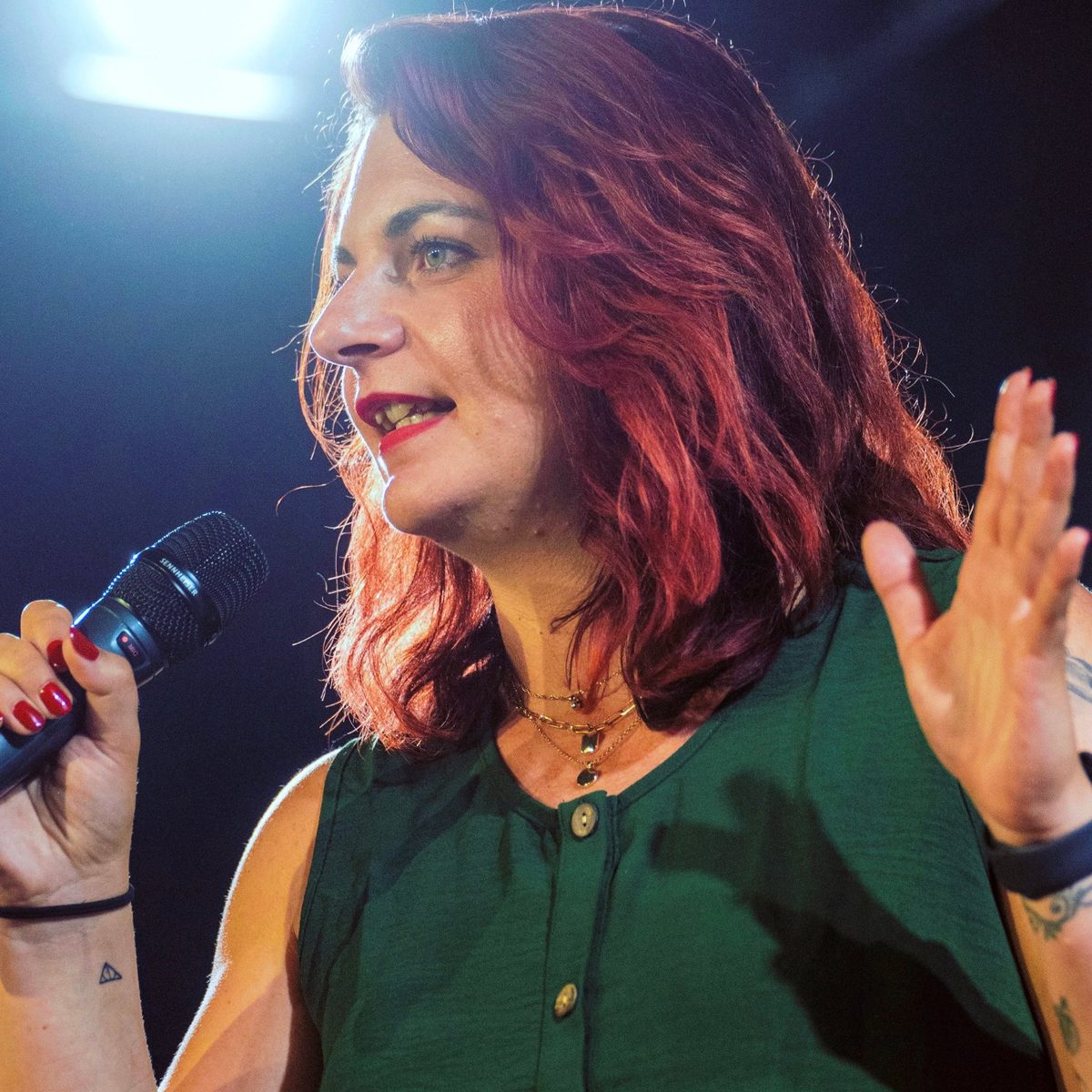 Mandy Henze spricht mit Mikrofon auf einer Bühne